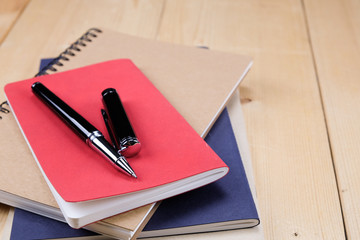 pen and book on wood background