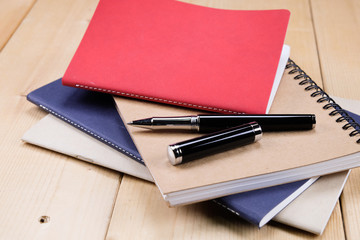 pen and book on wood background