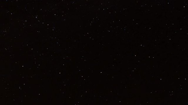 Night time lapse stars passing over mountains and distant ocean