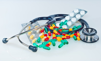 medical concept with colorful pills and stethoscope on white
