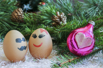 Fototapeta na wymiar Lovers on New year and Christmas . Unusual eggs with faces, faces. The love of two eggs, cartoon Christmas.