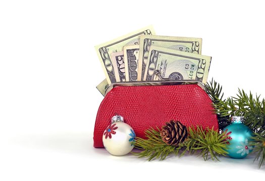 money in red purse with Christmas ornaments isolated on white