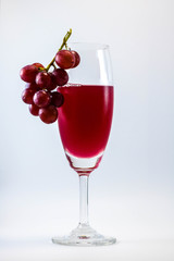 glass of red grapes on a white background