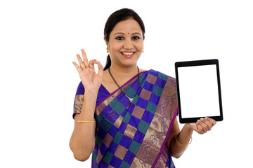 Traditional Indian woman using a tablet computer with OK gesture