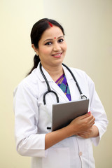 Traditional young female doctor holding tablet computer - 125031380