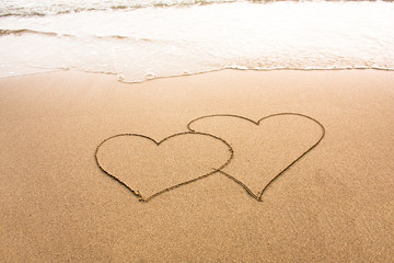 Hearts drawn in the sand, love or romance concept