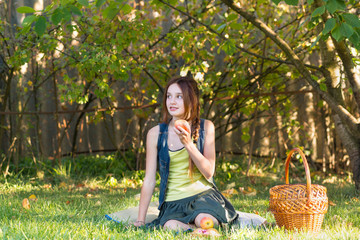 Teen girl in the garden eating Apple