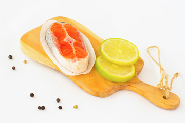 Piece of raw salmon and two slices of lemon