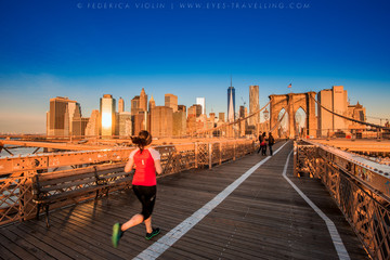 Naklejka premium Fitness kobieta biegacz relaks po mieście działa i na zewnątrz w Nowym Jorku, USA. Dziewczyna patrzeje i cieszy się widok most brooklyński. Mieszane rasy azjatyckich kobiet rasy kaukaskiej modelu.
