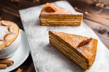 honey cake on a brown table with cup of coffe