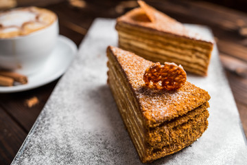 honey cake on a brown table with cup of coffe