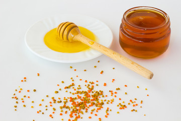 Jar with a dark honey. Dipper honey with a light honey. Pollen o