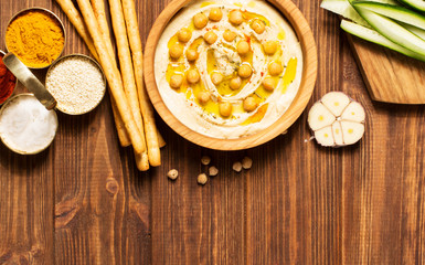 Hummus on a wooden background, soft focus, horizontal, top view