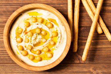 Hummus on a wooden background, soft focus, horizontal, top view, close-up