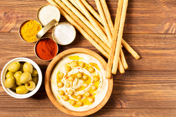 Hummus on a wooden background, soft focus, horizontal, top view