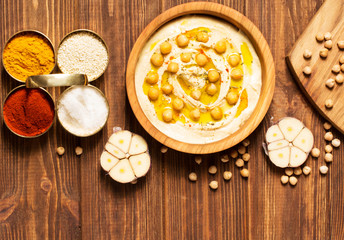Hummus on a wooden background, soft focus, horizontal, top view