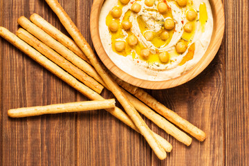 Hummus on a wooden background, soft focus, horizontal, top view, close-up