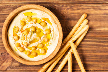 Hummus on a wooden background, soft focus, horizontal, top view, close-up