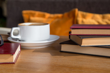 cup of latte or cappuccino coffee with a book in coffee shop