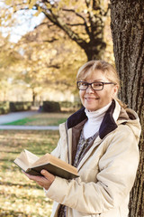 Cute mature woman in autumn park