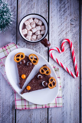 Christmas brownie for kids traditional homemade chocolate sweet dessert food and hot chocolate, cacao with marshmallow,candy cane on wooden table background. Top view, copy space