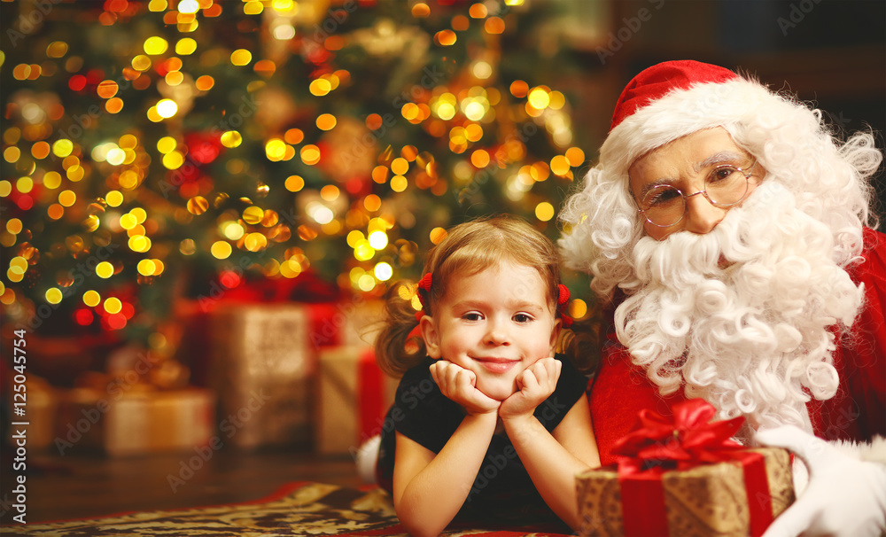 Wall mural happy child girl hugging Santa