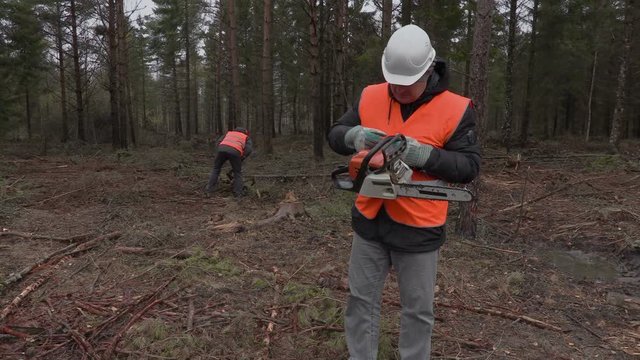 Lumberjack with chainsaw in forest