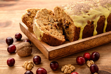 Gluten free carrot cake with cranberries on brown background.