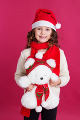 Child girl in santa hat on red background