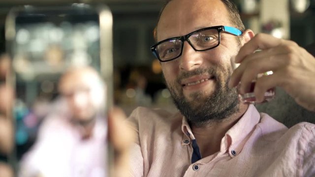 Happy man taking selfie photo with cellphone in cafe, 4K

