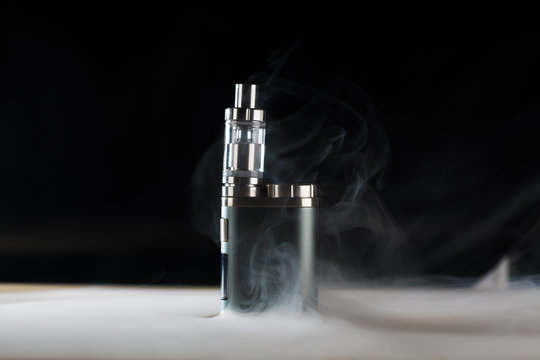 
electronic cigarette, vape with a smoke on a black background