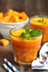 Two portions of fresh pumpkin juice with mint leaf in a glasses.