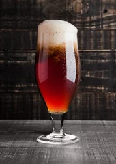 Papier Peint photo Bière Glass of brown ale beer with foam on wood