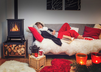 woman sitting on a cosy sofa beside fireplace