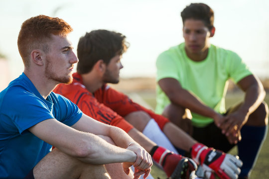 Three soccer players sitting - Powered by Adobe