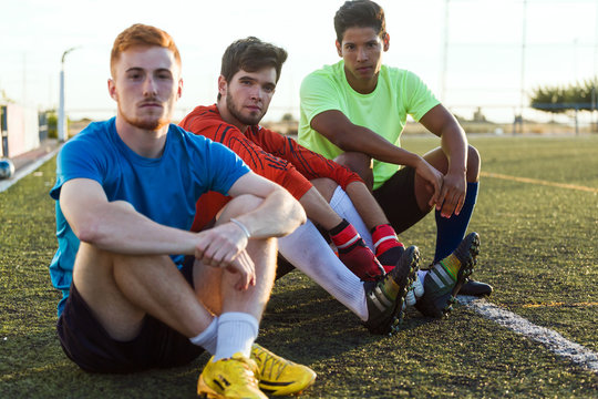Portrait of soccer players sitting on soccer pitch