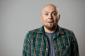 Portrait of surprised young handsome man smiling over beige background.