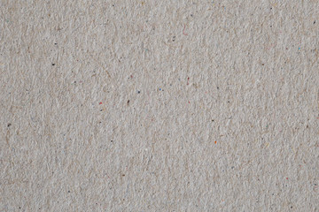 texture of the recycled paper interspersed with fibers and dust.