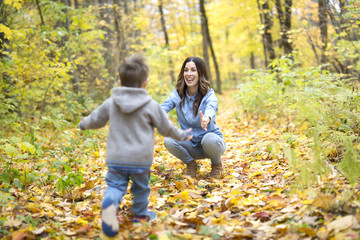 Naklejka premium Mother with son in forest in autumn