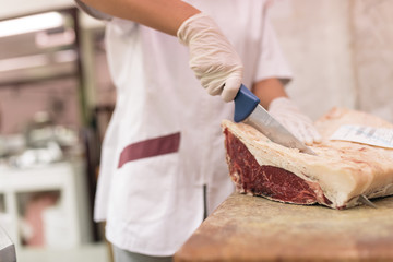 Butcher woman cutting meat.