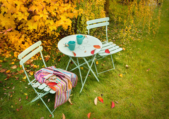 Obraz na płótnie Canvas Colorful autumn garden nook with hot tea and blanket