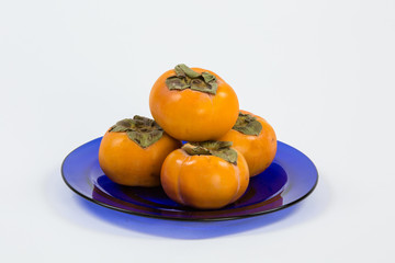 Persimmon group on blue clear plate on white background