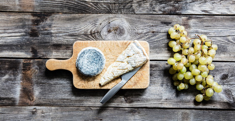 still-life of French Brie, goat cheese and white grape