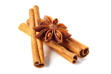 Three cinnamon sticks and star anise on white