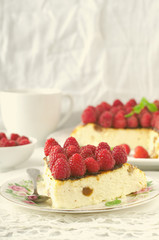 Cheesecake, souffle, cream mousse, pudding dessert with fresh raspberries and mint leaves on a white plate