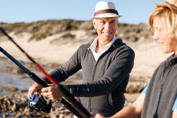 Obraz premium Senior man fishing with his grandson