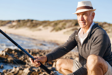 Senior man fishing at sea side