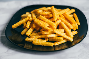 Corn snacks are on the black plate. White background