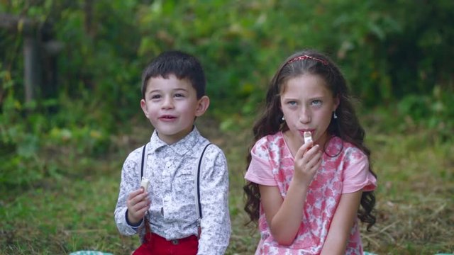 Little children eat sweets in the garden.