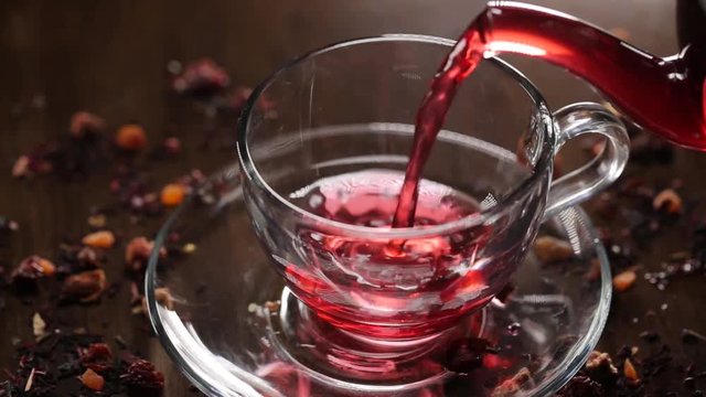 Hibiscus tea pouring into transparent glass
